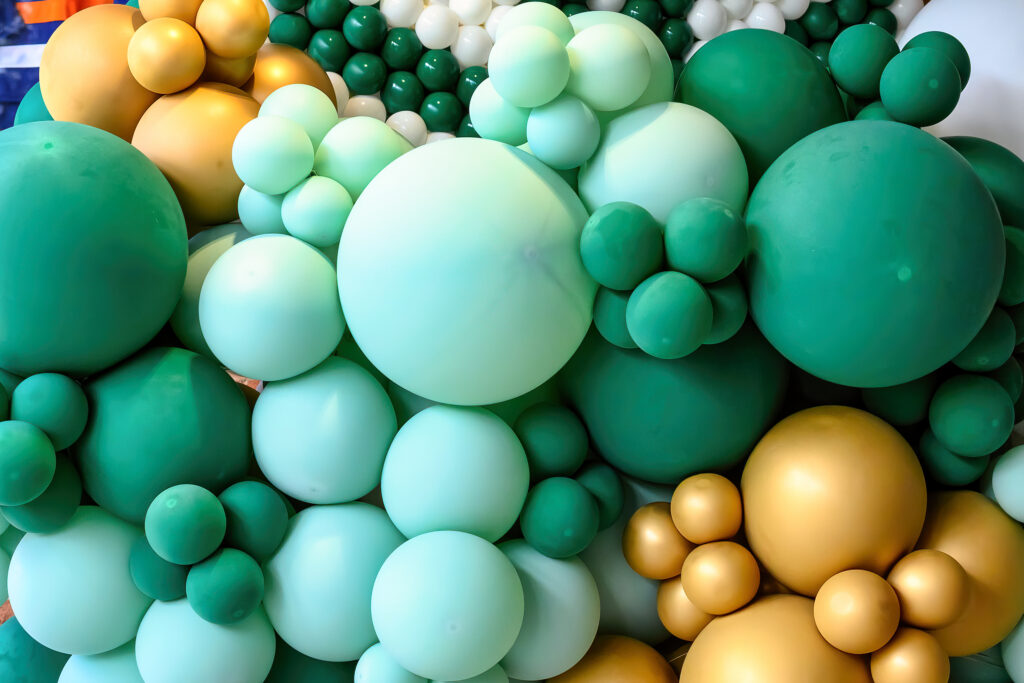different sized balloons in green and gold