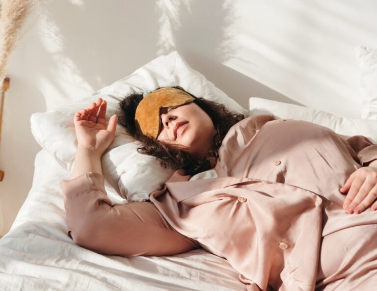 A woman sleeps restfully on her side, seeming to smile peacefully in her rest.