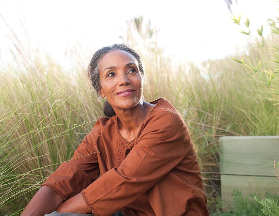 Older woman smiling in a field