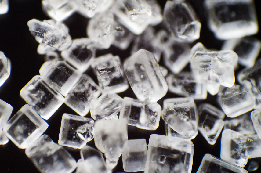 Extreme close-up of clear sugar crystals against a black background