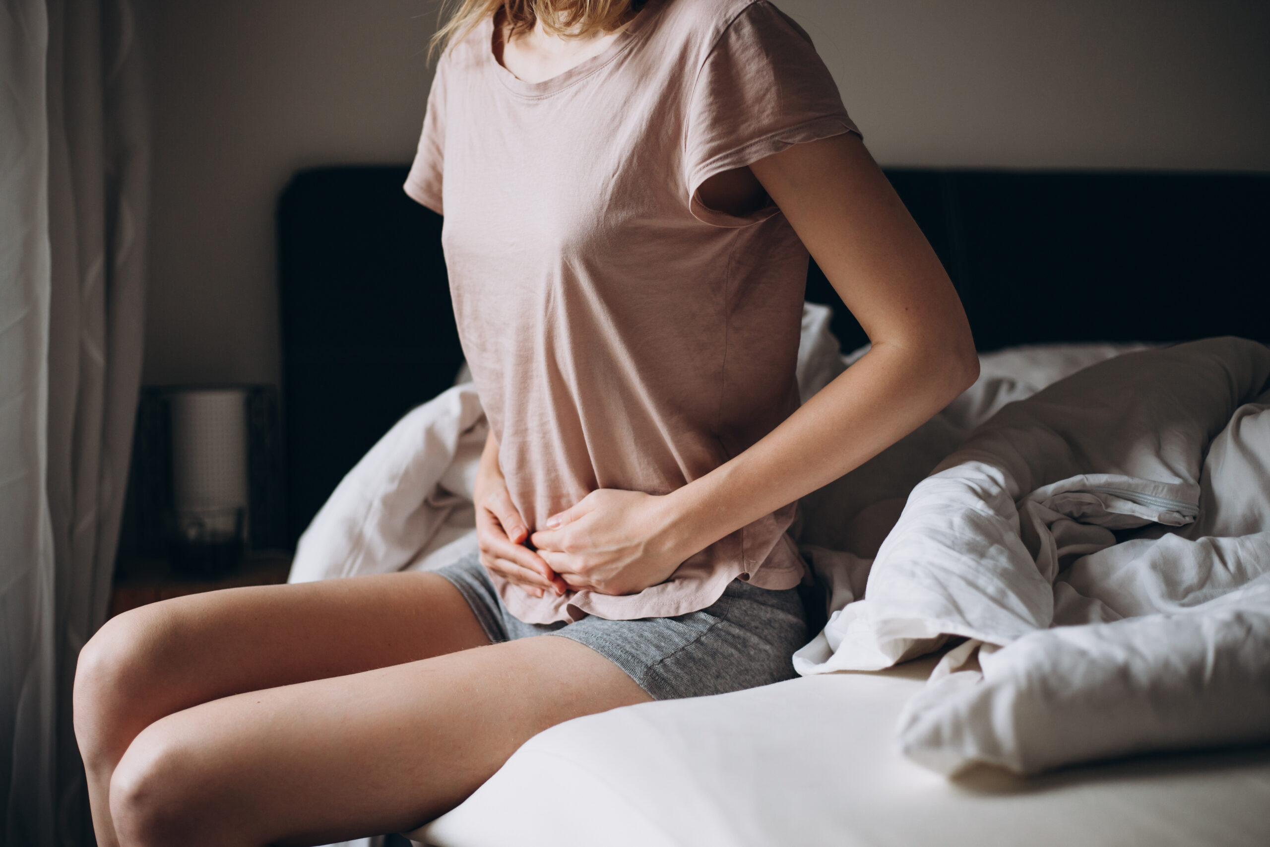 woman holding stomach signaling pain