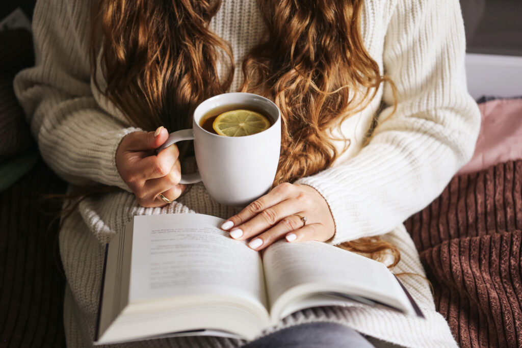 woman reading book and drinking tea