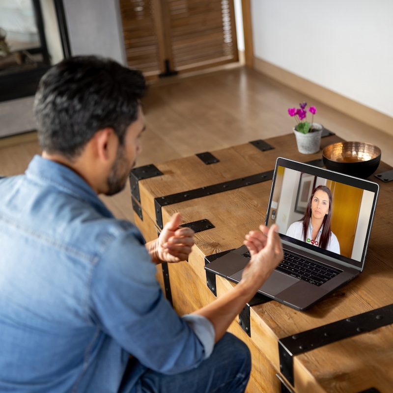 Man at home talking to his doctor on a video call