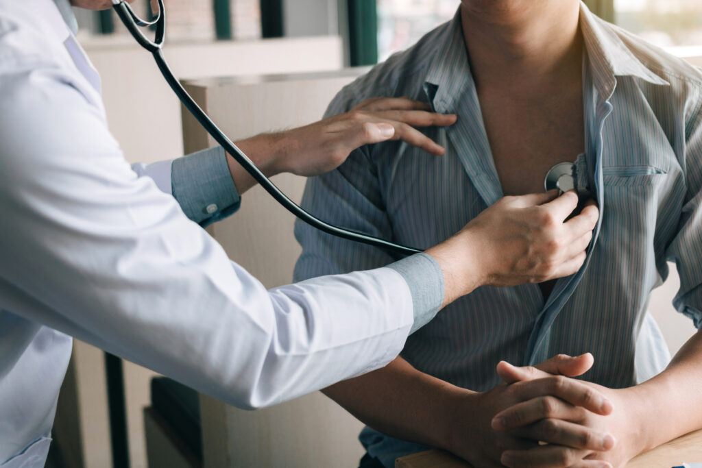 man getting his heart checked at doctor's office with stethascope