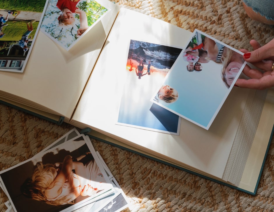 Close up of a photo album as a woman organizes pictures of her family.