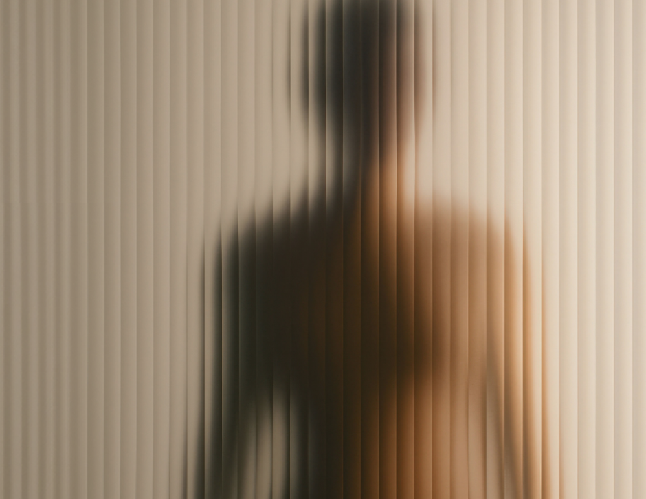 womans body behind frosted glass